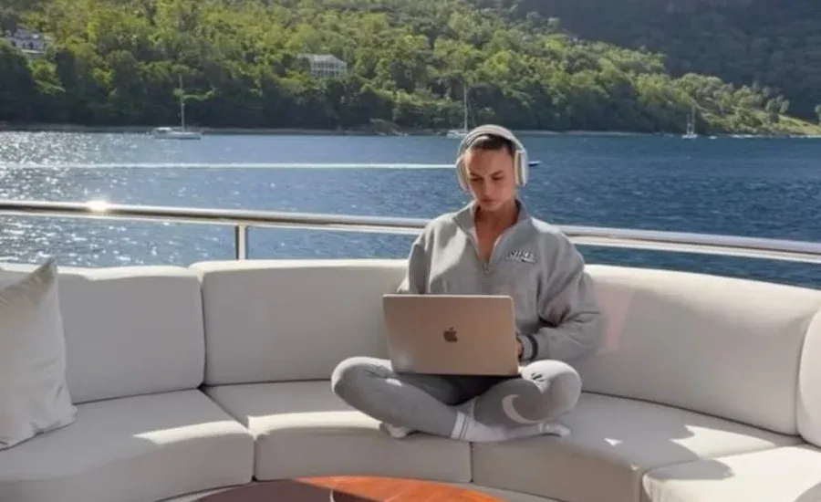 woman working on her laptop on a yacht doing her side job