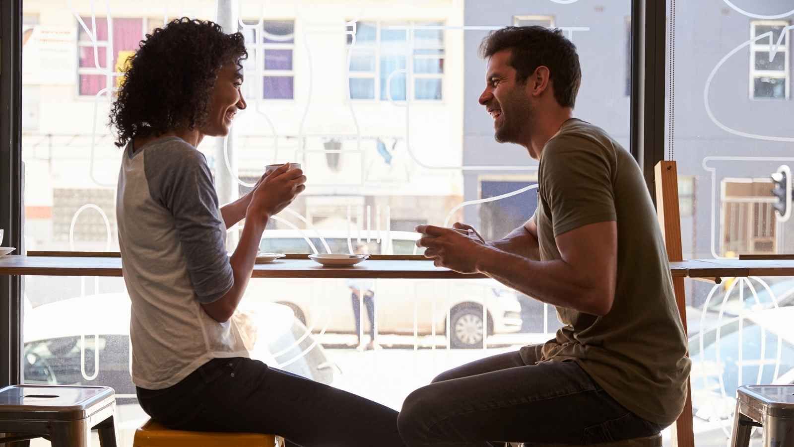 Couple on a coffee date with man talking excessively while woman listens patiently