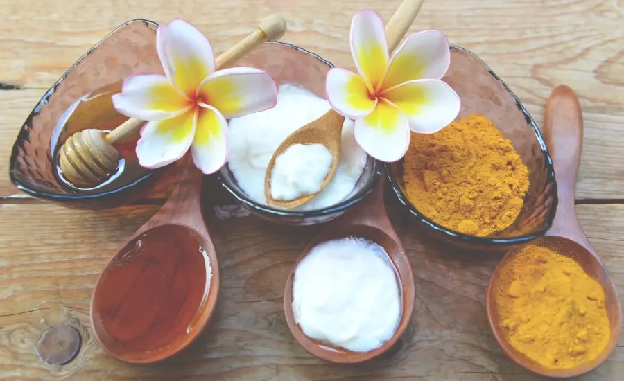 turmeric in a spoon, honey in a spoon, flowers