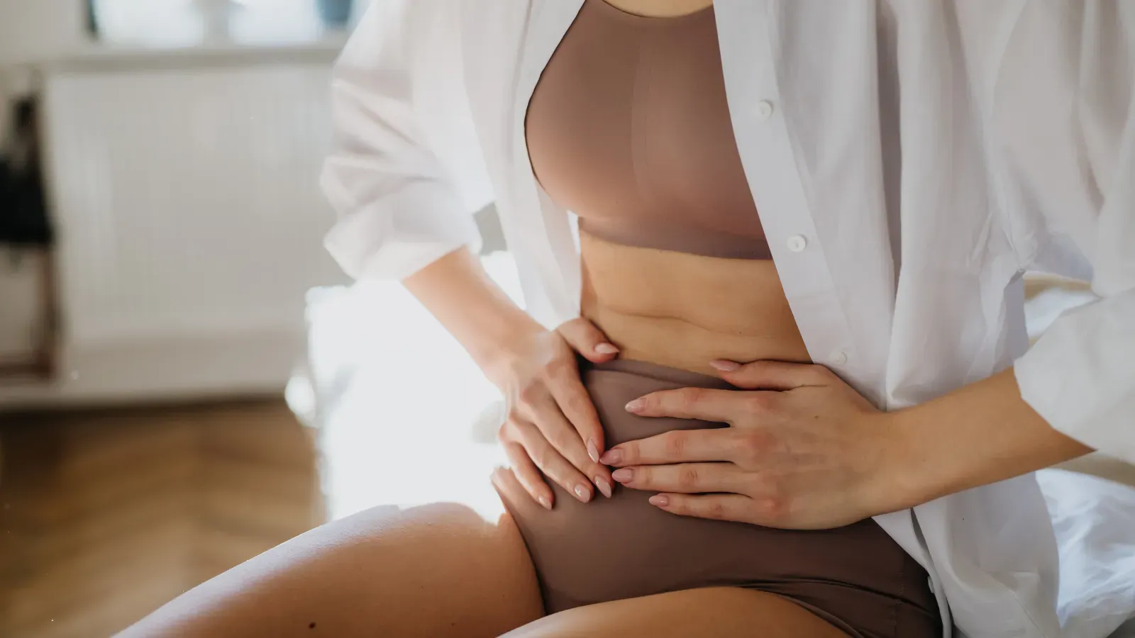 Woman holding bloated stomach in pain for minimizing water retention and abdominal discomfort