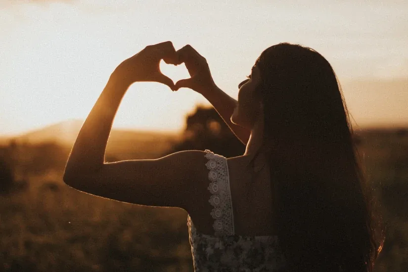girl making a heart symbol with her hands