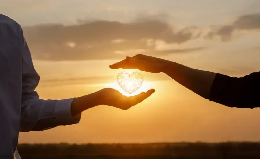 sunset two hands hold a heart