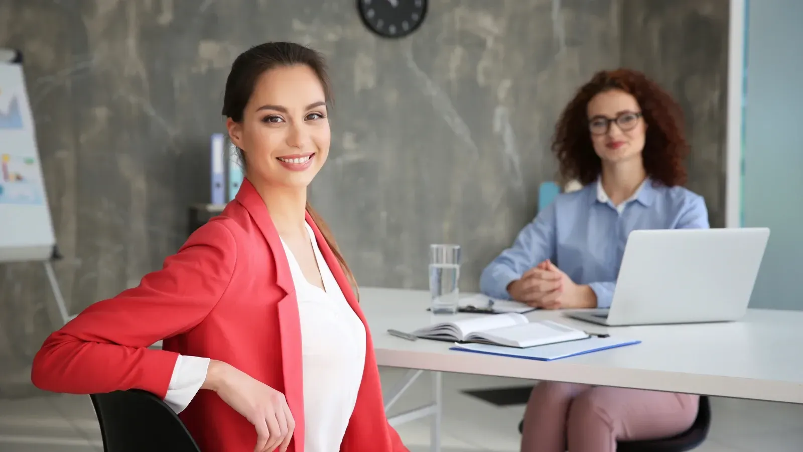 women sitting in office desk and looking at the camera