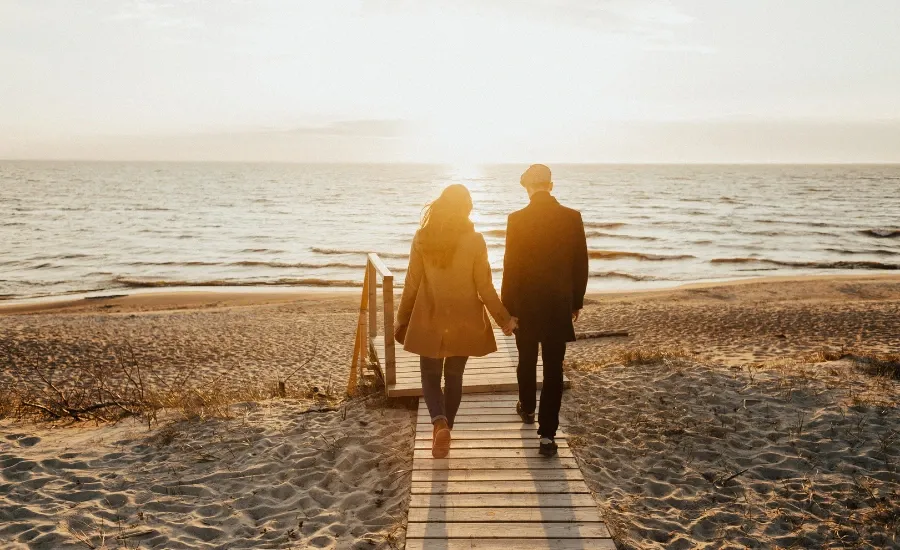 woman and man walking in the beach