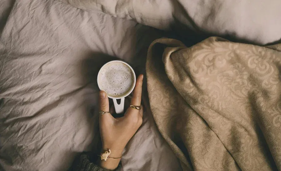 woman holding a cup of coffee in october morning