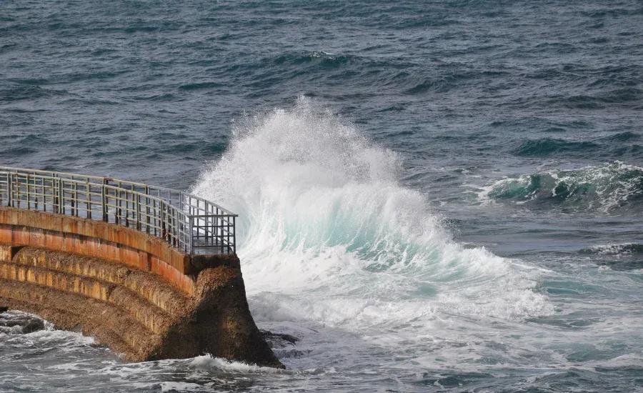 fence setting a boundary to the sea waves