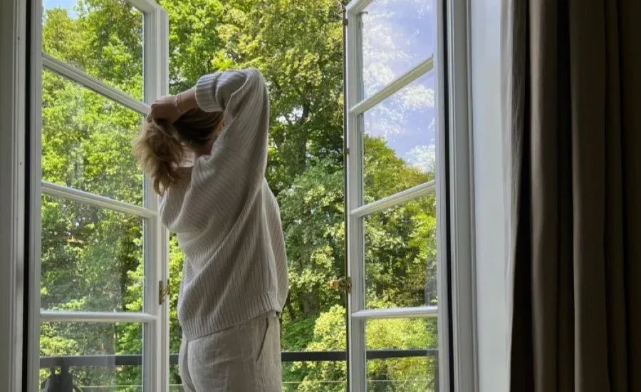 woman gazing through her home window