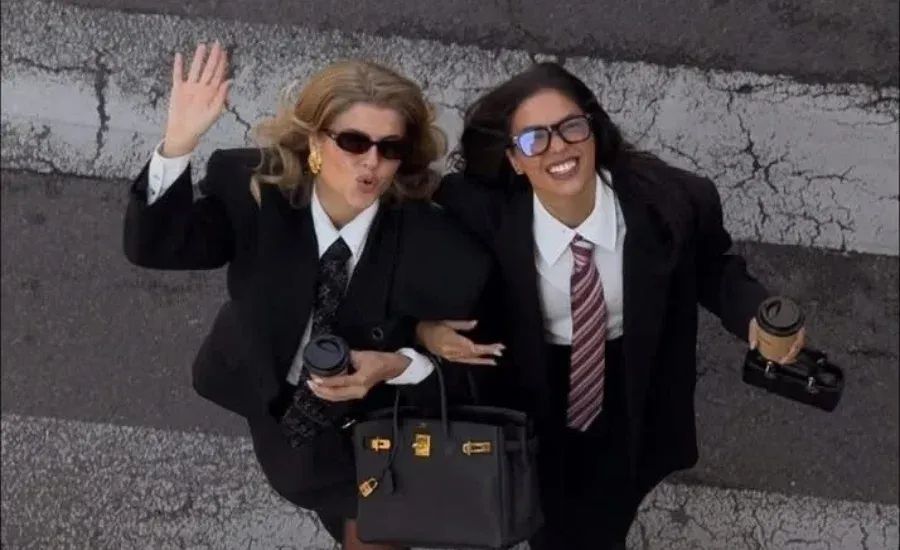 two professional women crossing the street and smiling